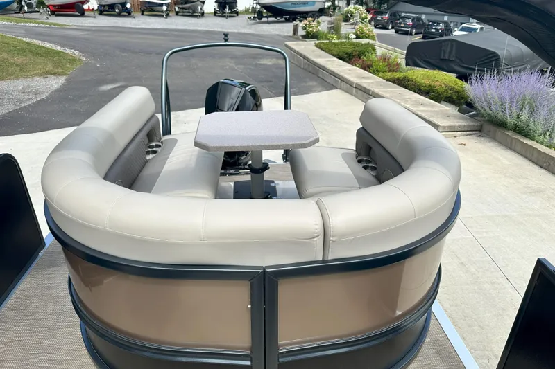 Slide: The Image of 2021 Premier 250 Solaris RE pontoon boat with beige seating and table, docked outdoors. - 13