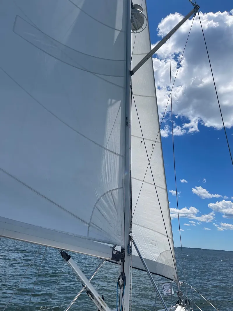 Slide: The Image of Sailboat on the water with white sails under a blue sky. - 38