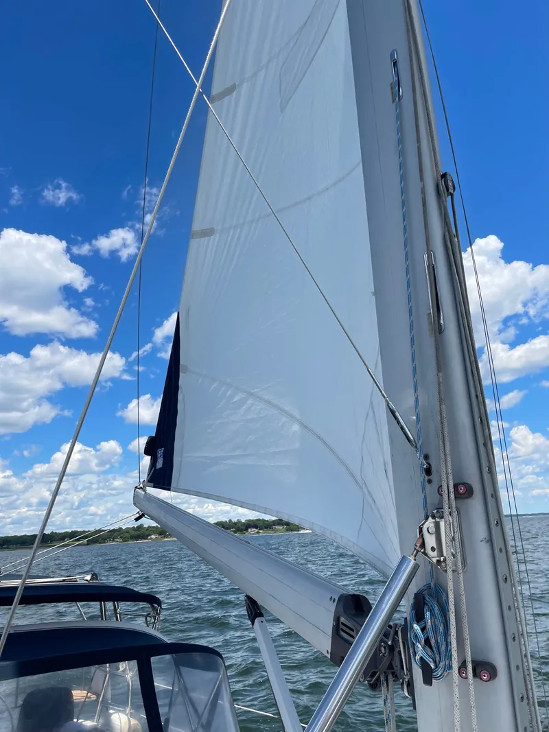 Slide: The Image of Sailboat with white sails on open water under a blue sky. - 41