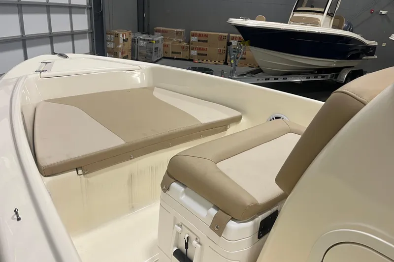 Slide: The Image of 2025 Scout 175 Sportfish boat interior with beige seating in a showroom. - 4