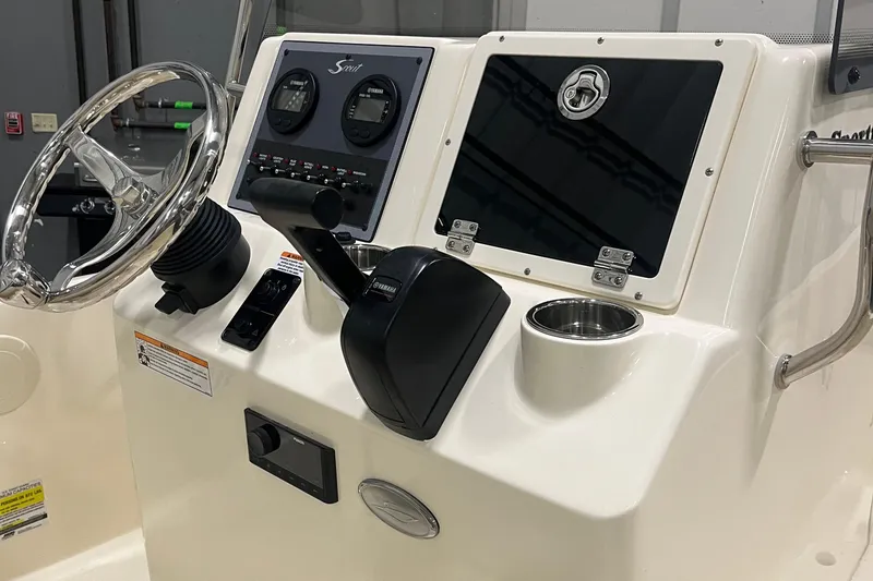 Slide: The Image of 2025 Scout 175 Sportfish boat console with steering wheel and controls. - 9