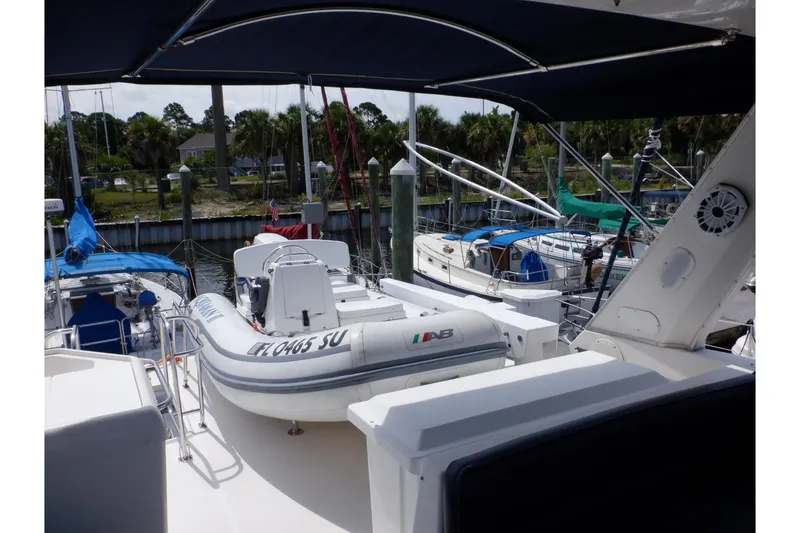 Slide: The Image of 1998 Bayliner 4788 Pilot House Motoryacht with inflatable boat on deck, docked at marina. - 19