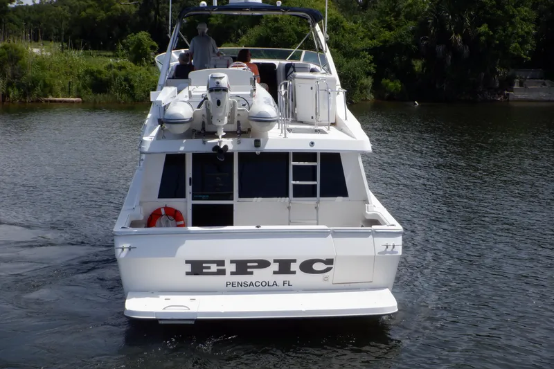 Slide: The Image of 1998 Bayliner 4788 Pilot House Motoryacht on water, rear view, named "Epic." - 2