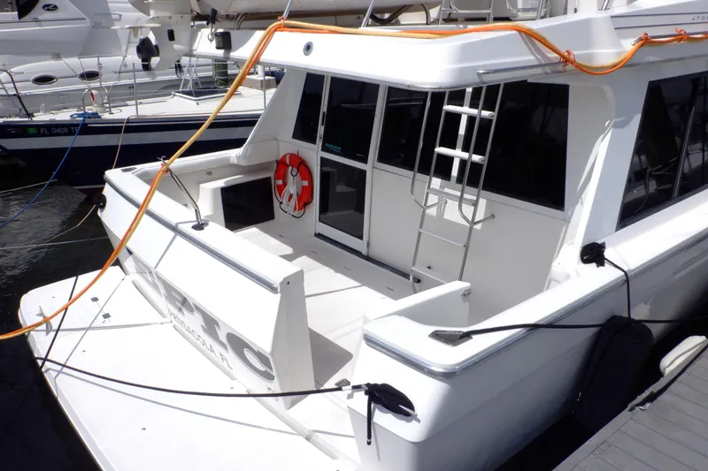 Slide: The Image of 1998 Bayliner 4788 Pilot House Motoryacht docked, featuring spacious deck and safety equipment. - 29