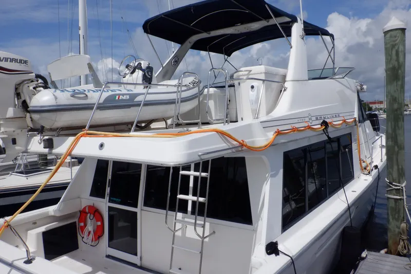 Slide: The Image of 1998 Bayliner 4788 Pilot House Motoryacht docked with inflatable boat on top. - 30