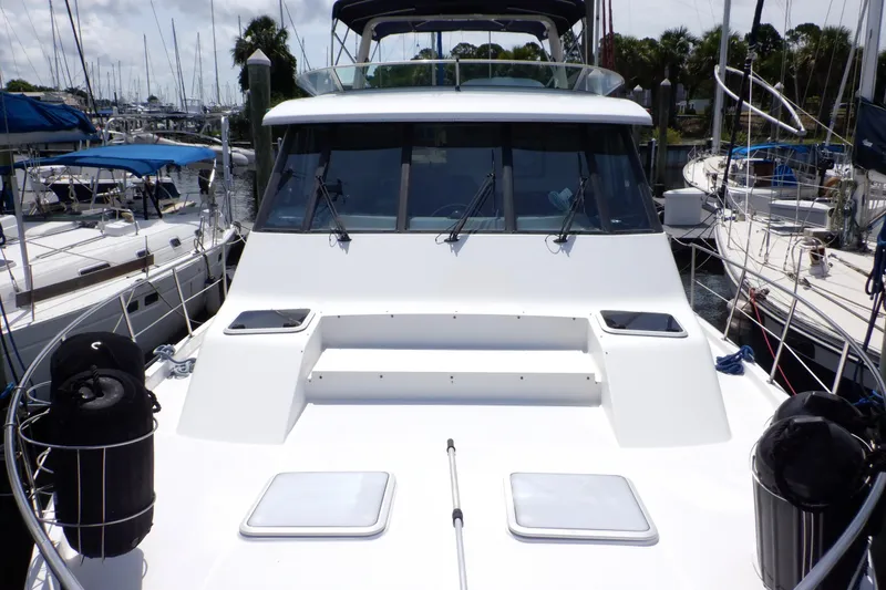 Slide: The Image of 1998 Bayliner 4788 Pilot House Motoryacht docked at marina, surrounded by sailboats. - 36