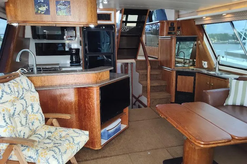Slide: The Image of Interior of 1998 Bayliner 4788 Pilot House Motoryacht with wood finishes and cozy seating. - 37