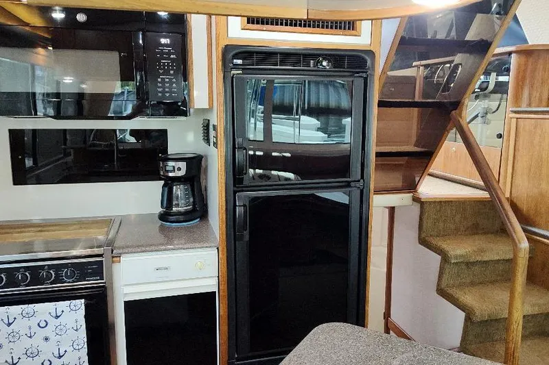 Slide: The Image of Interior of 1998 Bayliner 4788 yacht kitchen with appliances and stairs. - 40