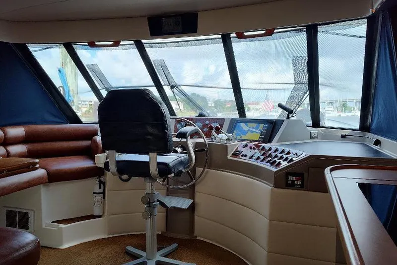 Slide: The Image of 1998 Bayliner 4788 Pilot House Motoryacht helm with leather seating and navigation controls. - 45
