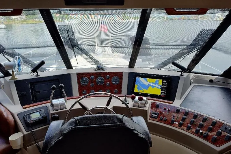 Slide: The Image of 1998 Bayliner 4788 Pilot House Motoryacht helm with navigation controls and dashboard. - 47