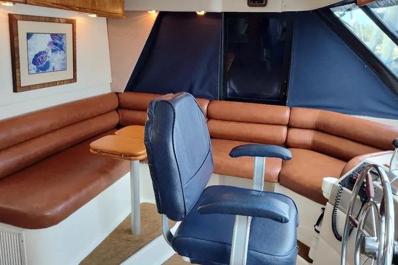 Slide: The Image of 1998 Bayliner 4788 Pilot House Motoryacht interior with leather seating and helm chair. - 53