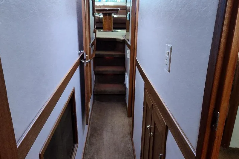 Slide: The Image of Interior hallway of 1998 Bayliner 4788 Pilot House Motoryacht with wooden accents and carpeted stairs. - 55