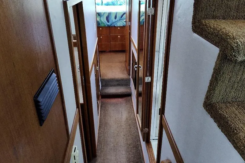 Slide: The Image of Interior hallway of 1998 Bayliner 4788 Pilot House Motoryacht, featuring carpeted stairs and wooden paneling. - 61
