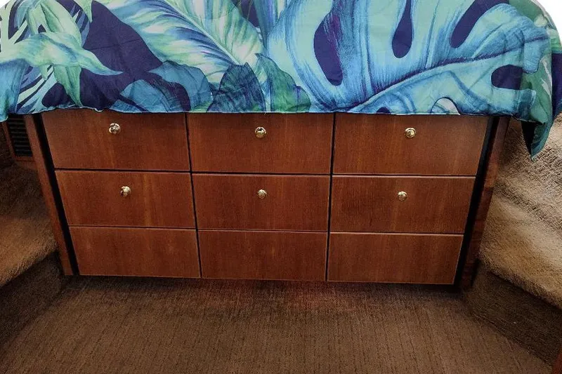 Slide: The Image of Wooden drawers with tropical leaf bedding on a 1998 Bayliner 4788 Pilot House Motoryacht. - 63