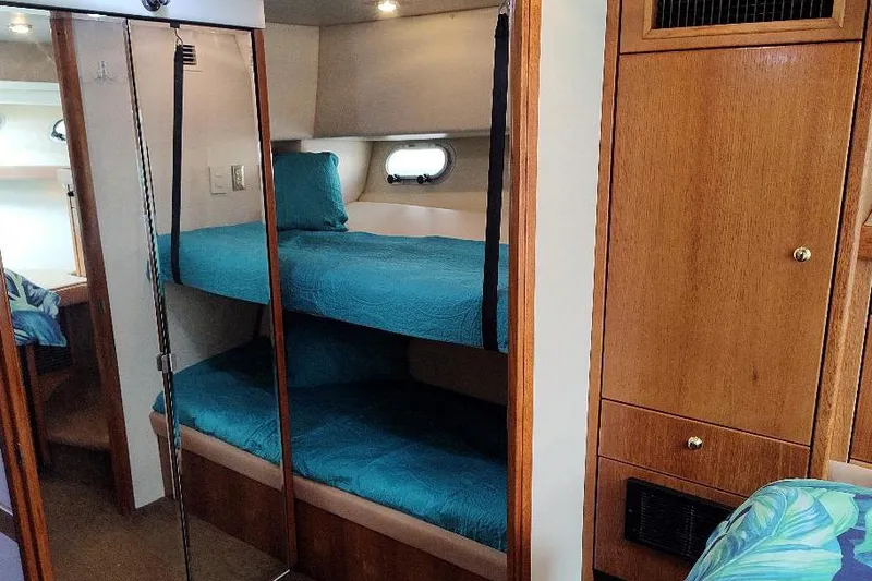 Slide: The Image of 1998 Bayliner 4788 Pilot House Motoryacht interior with bunk beds and wooden cabinetry. - 65