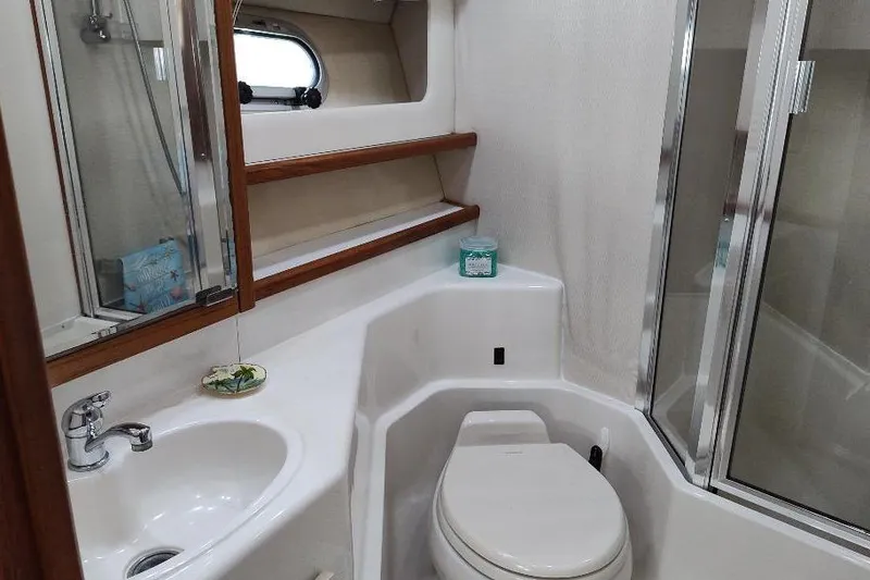 Slide: The Image of Bathroom interior of 1998 Bayliner 4788 Pilot House Motoryacht, featuring sink, toilet, and shower. - 67