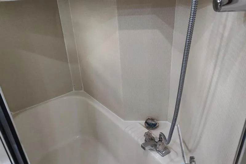 Slide: The Image of Shower area in 1998 Bayliner 4788 Pilot House Motoryacht, featuring chrome fixtures and beige walls. - 68