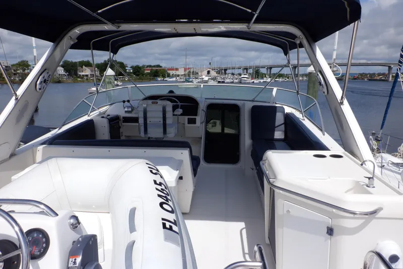 Slide: The Image of 1998 Bayliner 4788 Pilot House Motoryacht interior with seating and helm, docked in marina. - 7