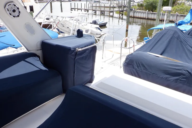 Slide: The Image of 1998 Bayliner 4788 Pilot House Motoryacht deck with blue covers at marina. - 70