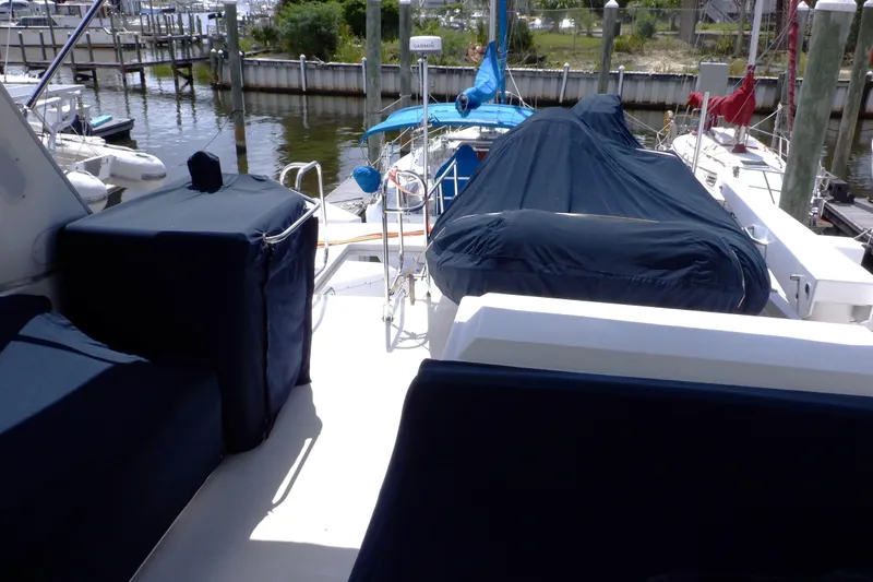 Slide: The Image of 1998 Bayliner 4788 Pilot House Motoryacht docked, covered seating and equipment visible. - 72