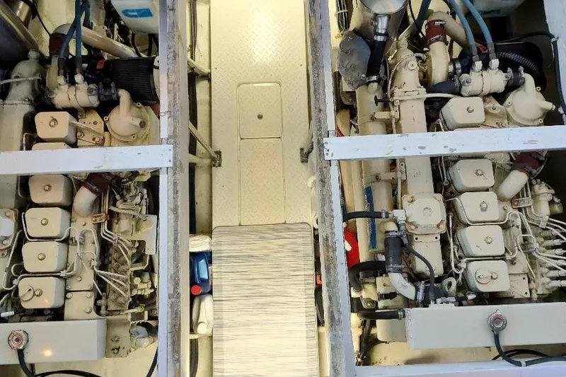 Slide: The Image of Engine room of 1998 Bayliner 4788 Pilot House Motoryacht, showcasing dual engines and mechanical components. - 74