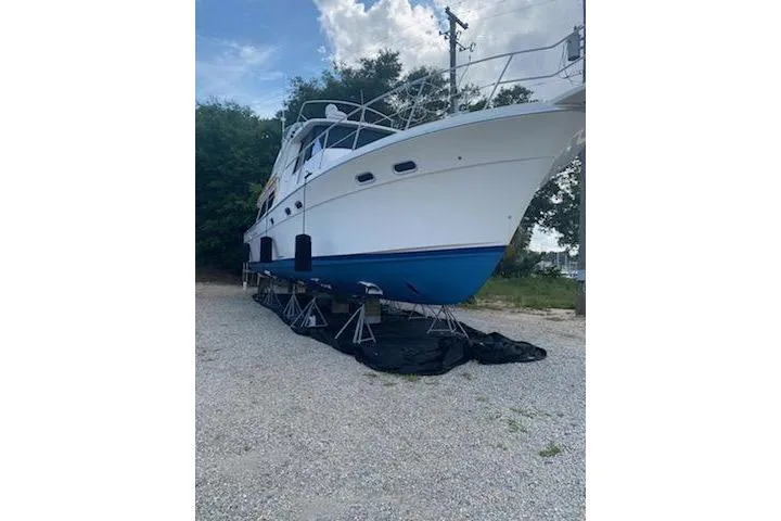 Slide: The Image of 1998 Bayliner 4788 Pilot House Motoryacht on stands, white hull, blue bottom, outdoor setting. - 78