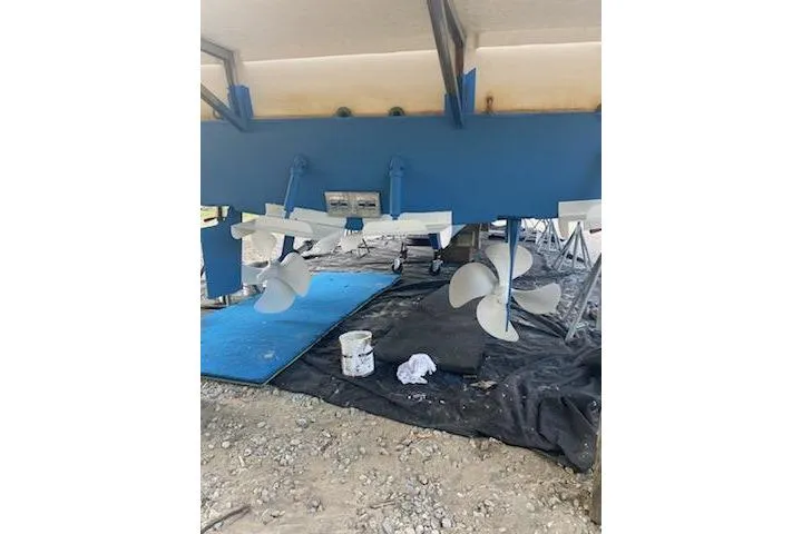 Slide: The Image of 1998 Bayliner 4788 Pilot House Motoryacht under maintenance, showing propellers and hull. - 79