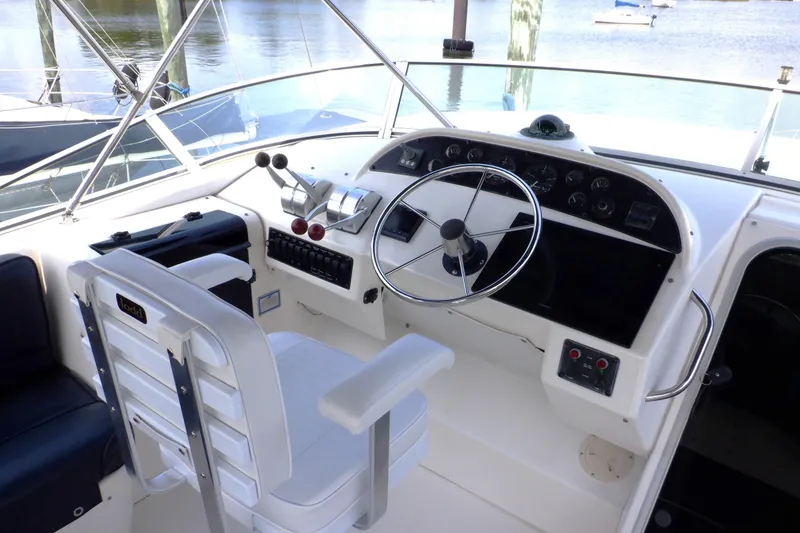 Slide: The Image of 1998 Bayliner 4788 Pilot House Motoryacht helm with steering wheel and control panel. - 8