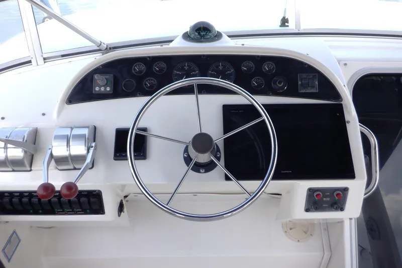 Slide: The Image of 1998 Bayliner 4788 Pilot House Motoryacht helm with steering wheel and control panel. - 9