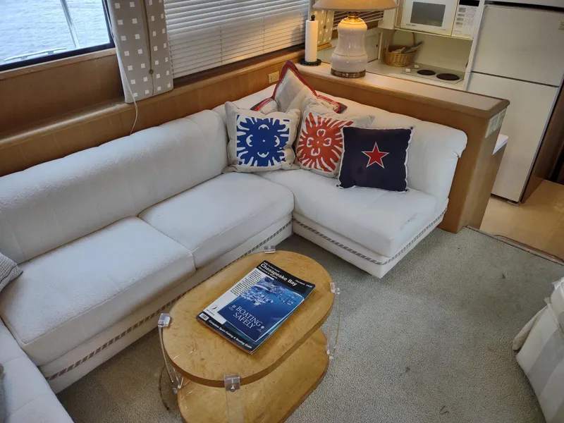 Slide: The Image of Interior of 1996 Hatteras 50' Sport Deck with cozy seating and nautical-themed pillows. - 19