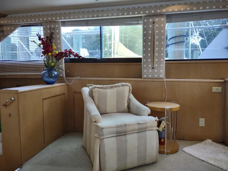 Slide: The Image of Interior of 1996 Hatteras 50' Sport Deck with armchair, side table, and floral arrangement. - 26
