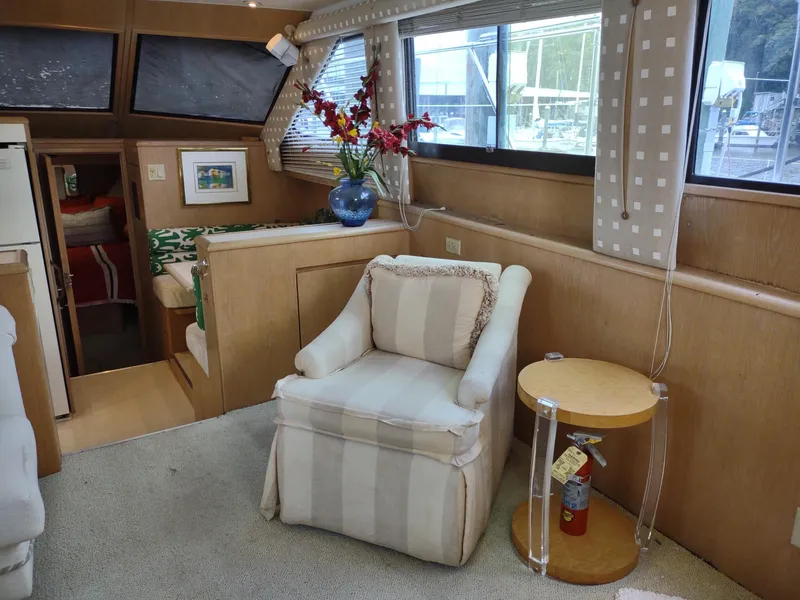 Slide: The Image of Interior of 1996 Hatteras 50' Sport Deck with armchair, table, and floral arrangement. - 30