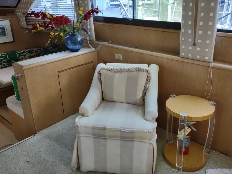Slide: The Image of Interior of 1996 Hatteras 50' Sport Deck with armchair, side table, and floral arrangement. - 31