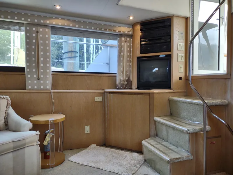 Slide: The Image of Interior of 1996 Hatteras 50' Sport Deck yacht with TV, stairs, and cozy seating area. - 33