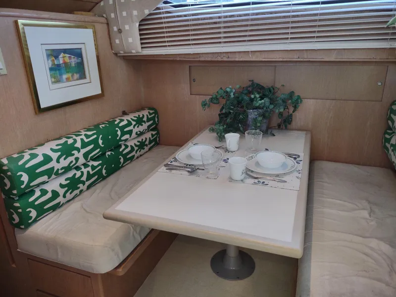 Slide: The Image of Dining area in 1996 Hatteras 50' Sport Deck with green cushions and table setting. - 40
