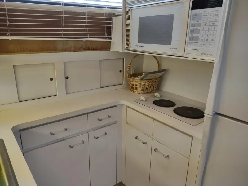 Slide: The Image of Compact kitchen in 1996 Hatteras 50' Sport Deck yacht with microwave and stove. - 44
