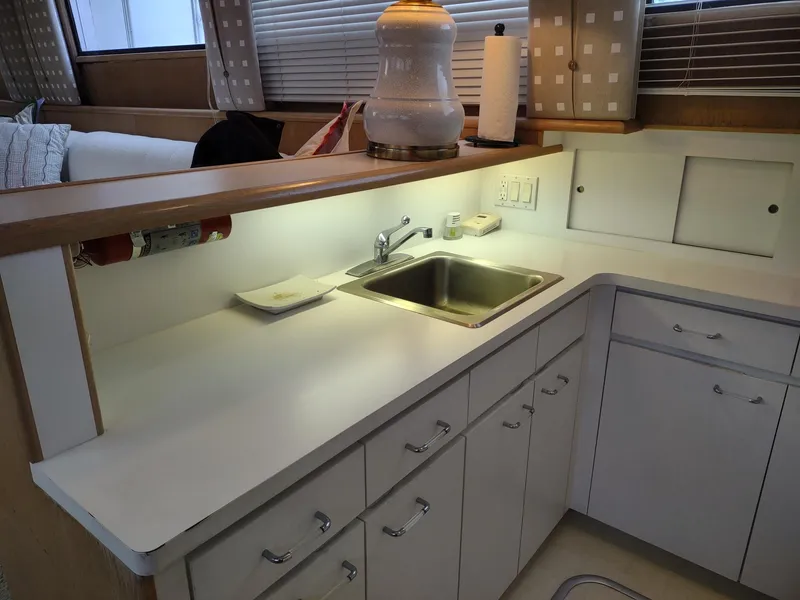 Slide: The Image of 1996 Hatteras 50' Sport Deck kitchen with sink, cabinets, and modern decor. - 45