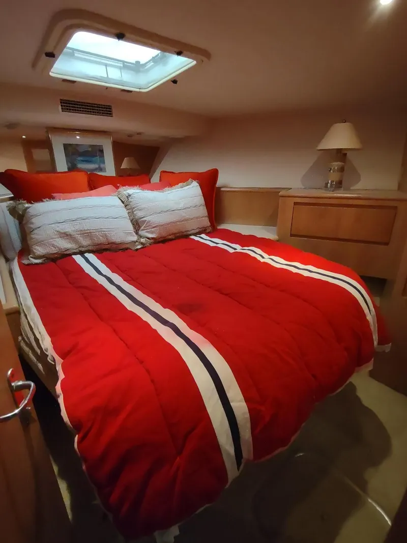 Slide: The Image of Cozy bedroom with red bedding in a 1996 Hatteras 50' Sport Deck yacht. - 49