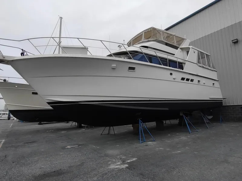 Slide: The Image of 1996 Hatteras 50' Sport Deck yacht on stands, side view, in a marina setting. - 9