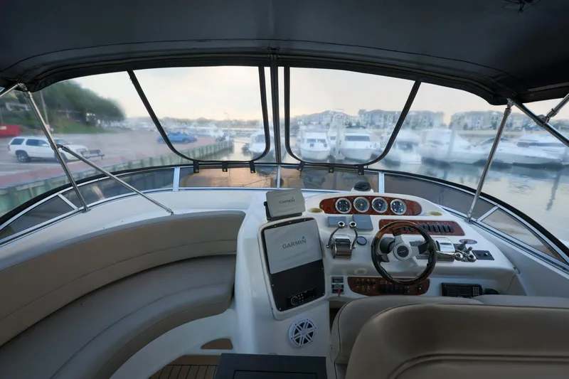 Slide: The Image of Interior view of 2004 Meridian 411 Sedan yacht helm with marina backdrop. - 3