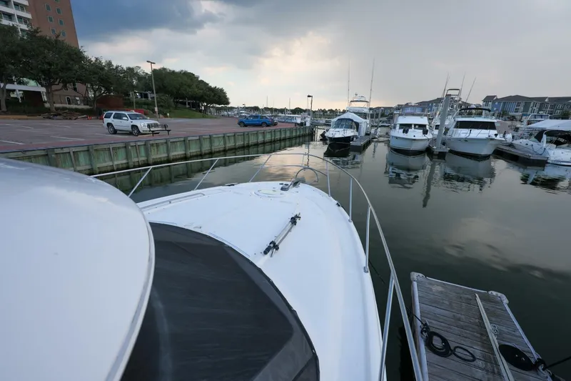 Slide: The Image of 2004 Meridian 411 Sedan docked at a marina with other boats under a cloudy sky. - 35