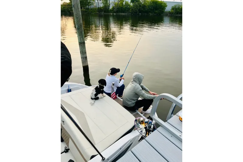 Slide: The Image of People fishing on a 2024 Monterey M-20 boat with a dog by the water. - 6