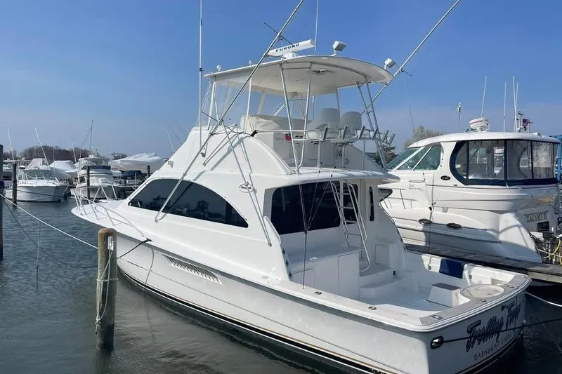 Slide: The Image of 2005 Ocean Yachts 46 Super Sport docked in a marina under a blue sky. - 2