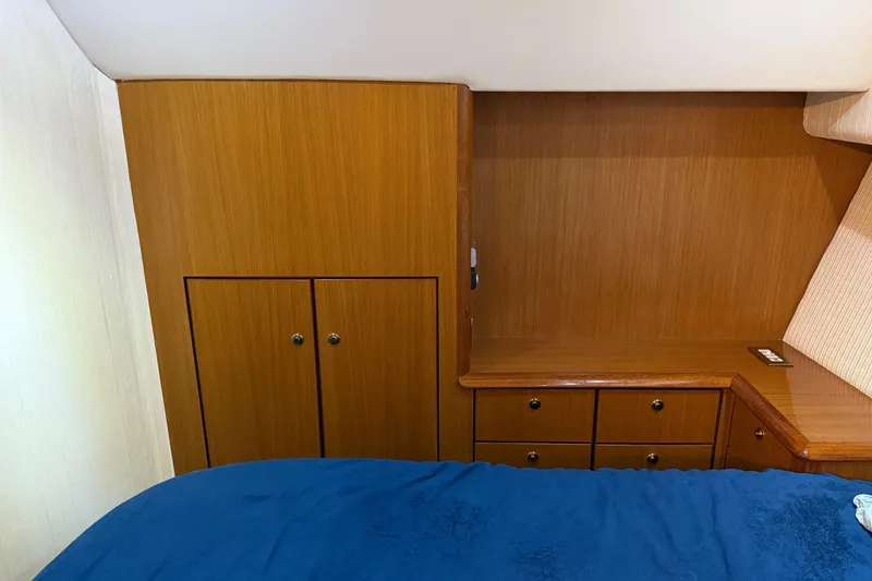 Slide: The Image of Interior of 2005 Ocean Yachts 46 Super Sport with wooden cabinetry and blue bedding. - 20