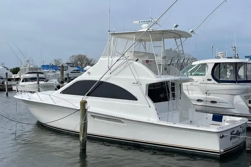 Slide: The Image of 2005 Ocean Yachts 46 Super Sport docked in a marina under a blue sky. - 0