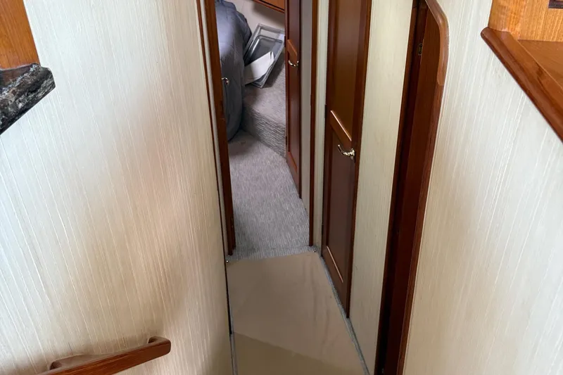 Slide: The Image of Interior hallway of 2005 Ocean Yachts 46 Super Sport, featuring wooden doors and carpeted flooring. - 17