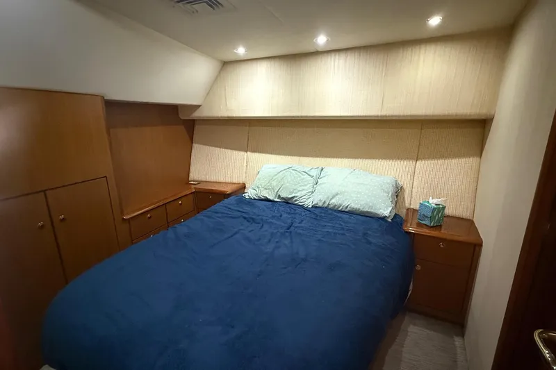 Slide: The Image of Luxurious bedroom in 2005 Ocean Yachts 46 Super Sport with cozy bedding and wooden cabinetry. - 18