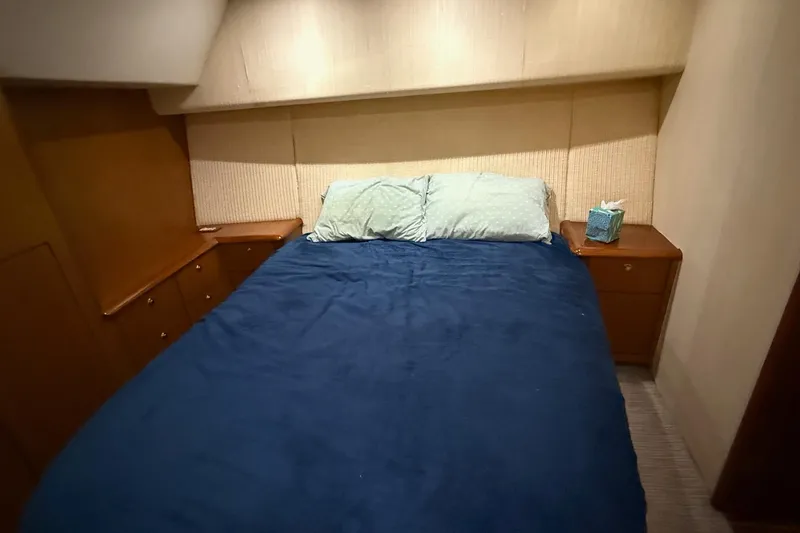 Slide: The Image of Cozy bedroom in 2005 Ocean Yachts 46 Super Sport with blue bedding and wooden cabinets. - 19