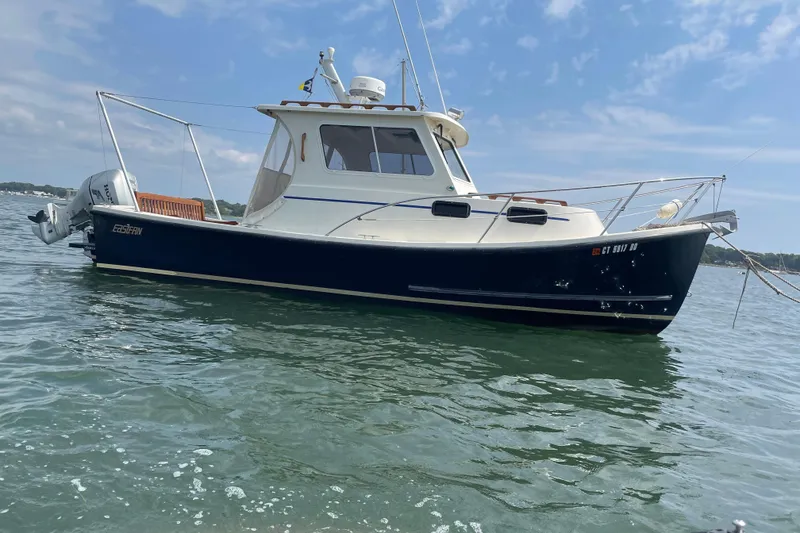Slide: The Image of 2009 Eastern 248 Explorer boat on calm water under a clear sky. - 0