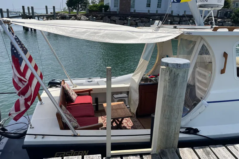 Slide: The Image of 2009 Eastern 248 Explorer boat docked, featuring canopy, seating, and American flag. - 1
